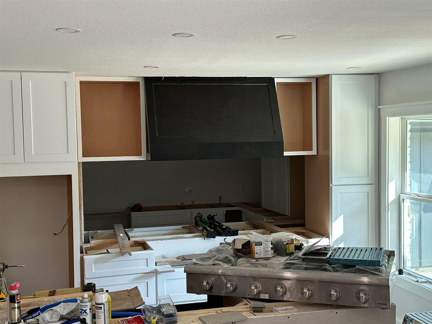Range hood and cabinetry installed above the cooking area