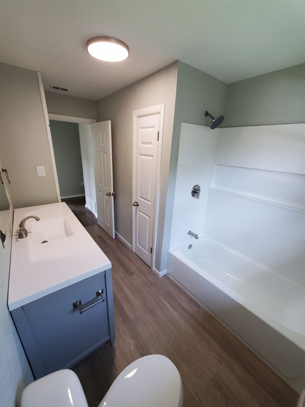 Remodeled bathroom with new vanity and tub surround, after photo