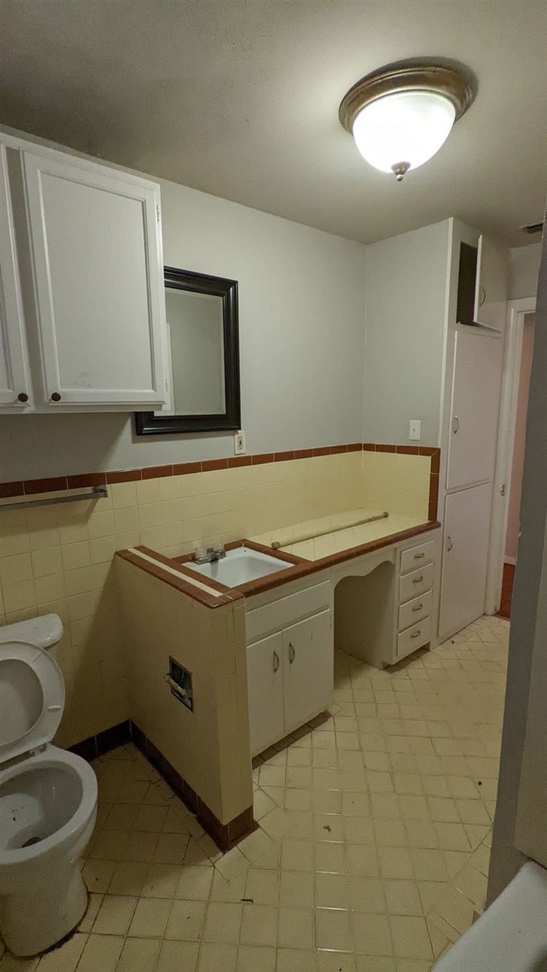 Dated bathroom with yellow tile before remodel